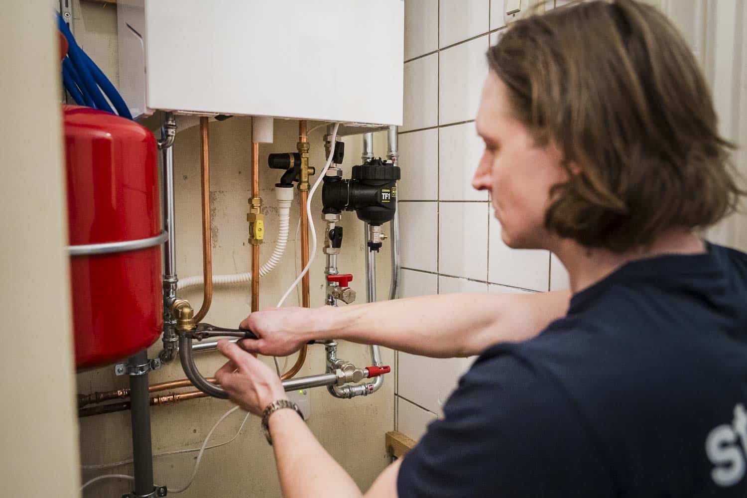 opleiding cv-installateur: monteur werkt aan boiler